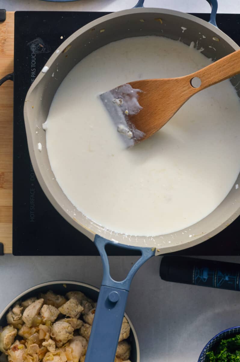 Whisking cream cheese and Greek yogurt into a pasta sauce.
