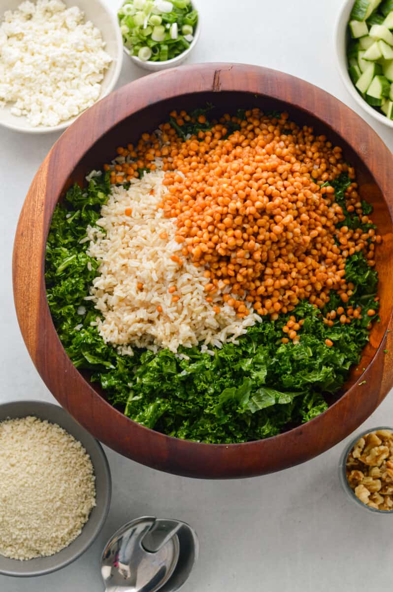 Adding lentils and brown rice to massaged kale.