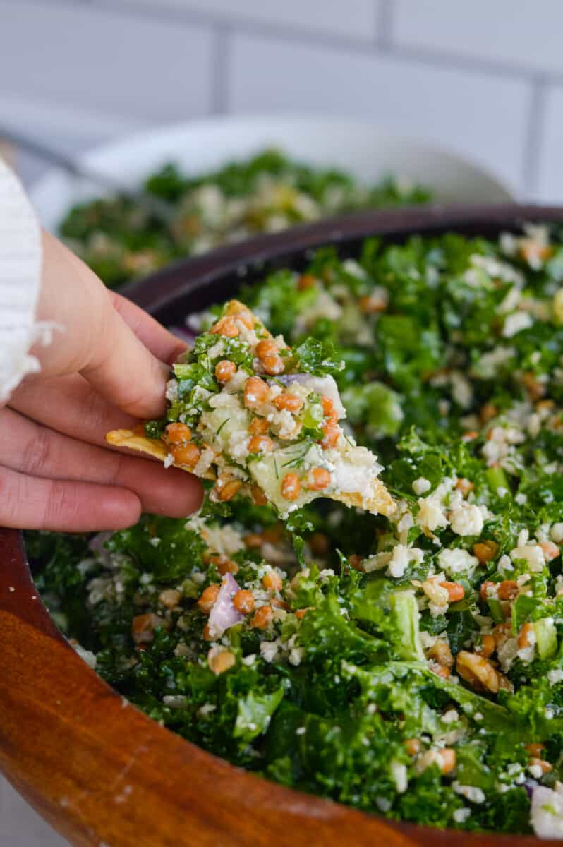 Dipping a chip into dill pickle salad.