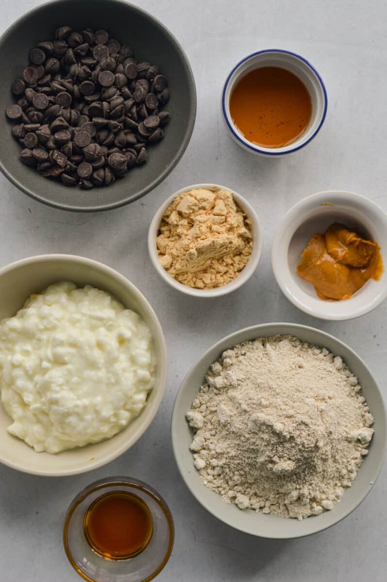 Ingredients including oat flour, cottage cheese, chocolate chips, protein powder, peanut butter, and vanilla extract.