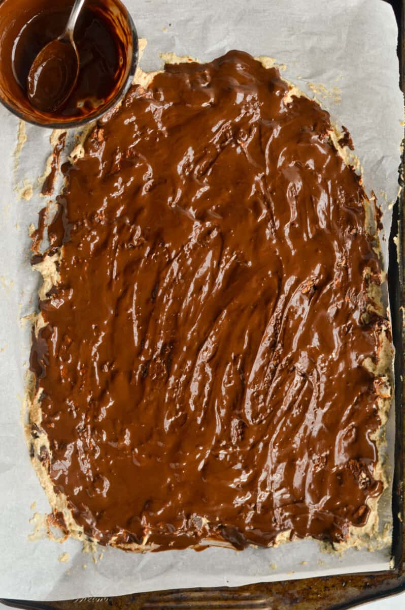 Spreading melted dark chocolate on cottage cheese cookie dough.