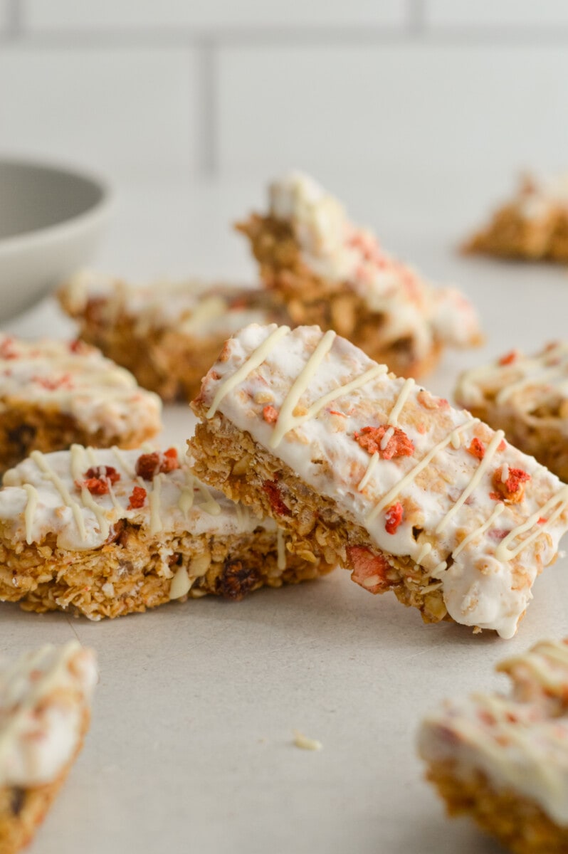 Stacks of granola yogurt bars with white chocolate drizzle.
