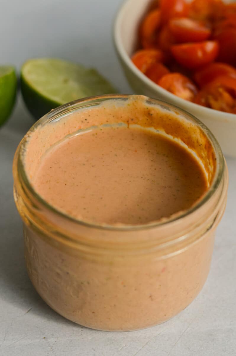 Jar of red salsa dressing.