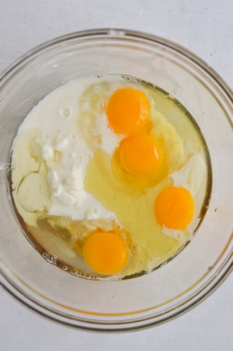 Eggs, cottage cheese, milk and olive oil in a bowl.