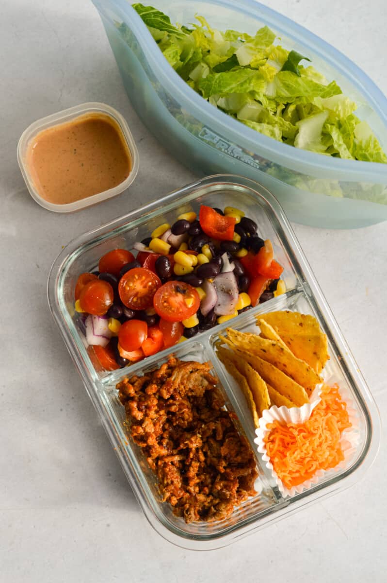 Adult lunchable with nacho salad components in separate sections.