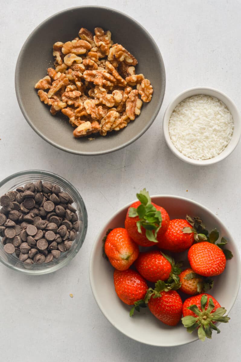 Toppings including walnuts, shredded coconut, strawberries and chocolate chips.