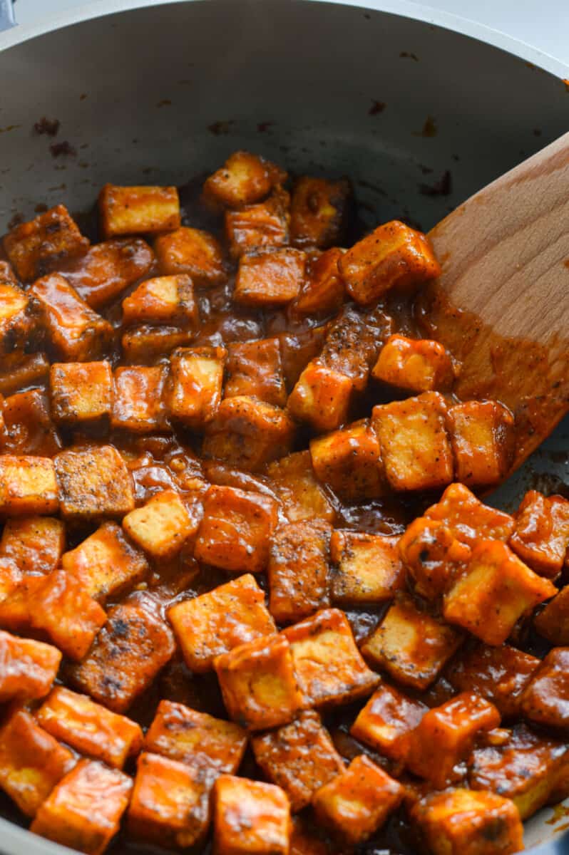 Cooking sticky orange tofu in a pan.