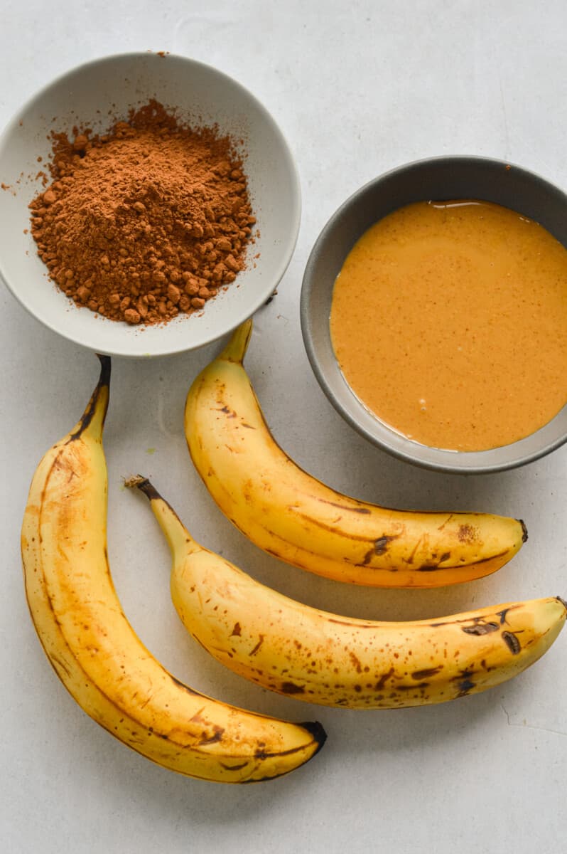 Ingredients including ripe bananas, cocoa powder and peanut butter.