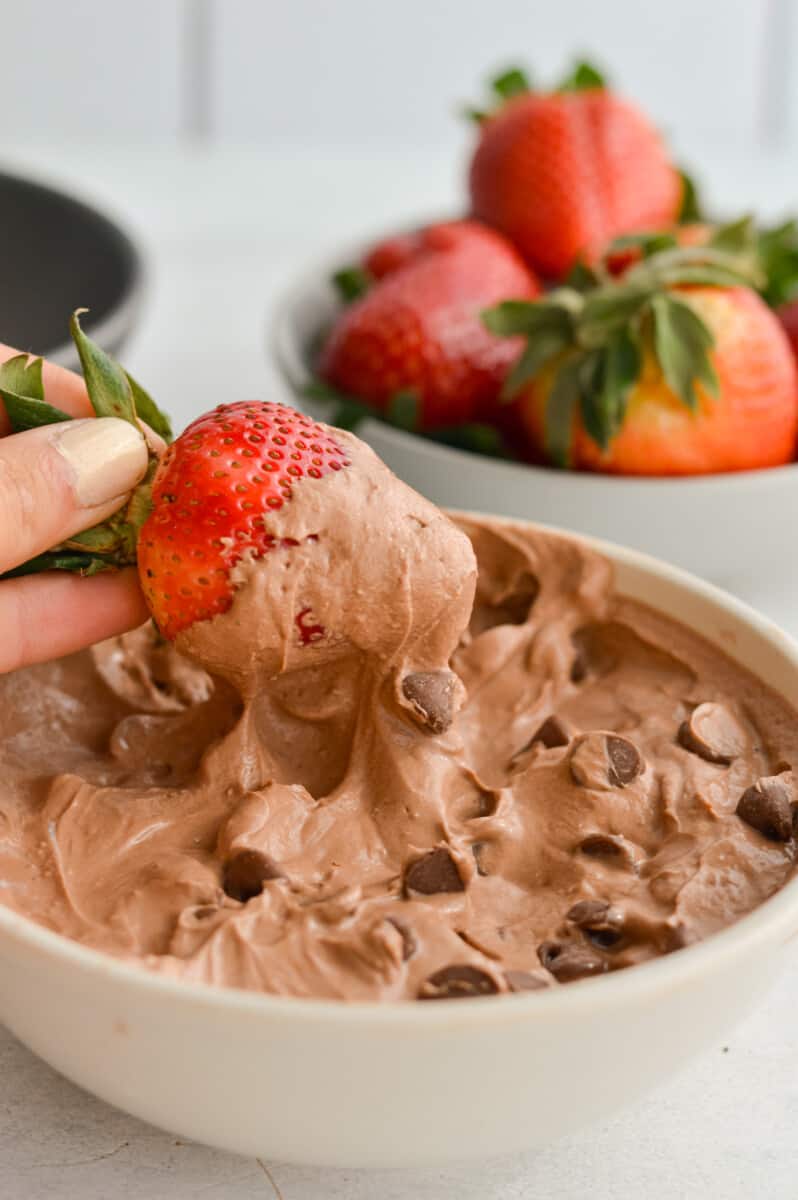 Dipping a strawberry in chocolate Greek yogurt.