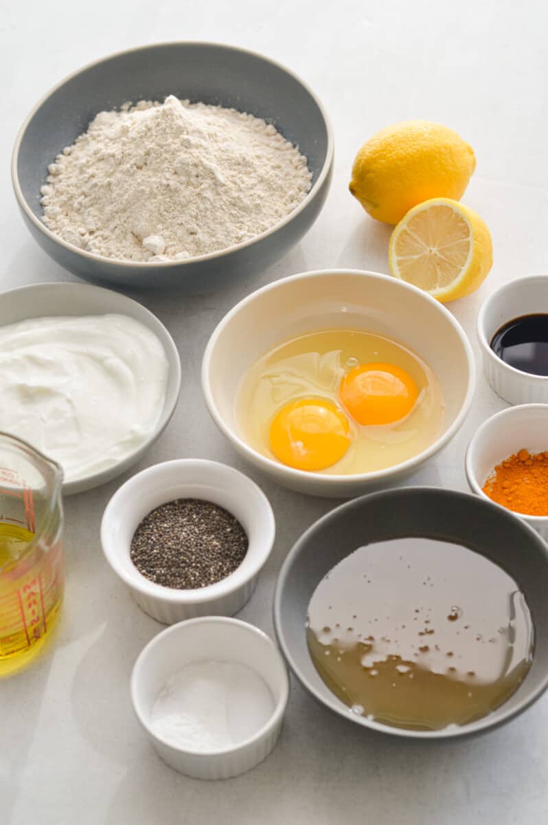 Ingredients including oat flour, eggs, Greek yogurt, olive oil, chia seeds, lemon, turmeric and honey.