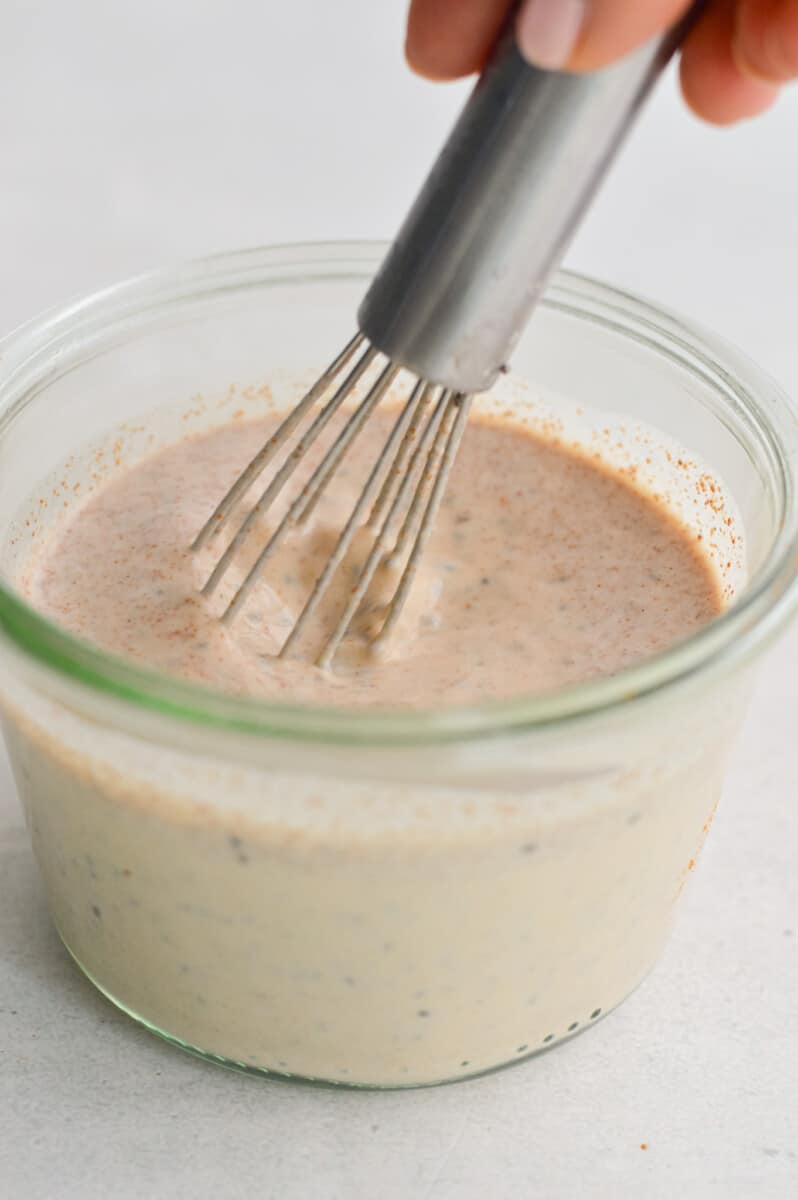 Mixing chia pudding with a whisk.