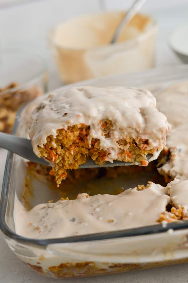 Lifting out a slice of carrot cake baked oatmeal with Greek yogurt icing.