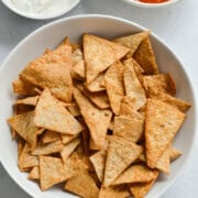 Bowl of air fryer tortilla chips, served with dip and salsa.