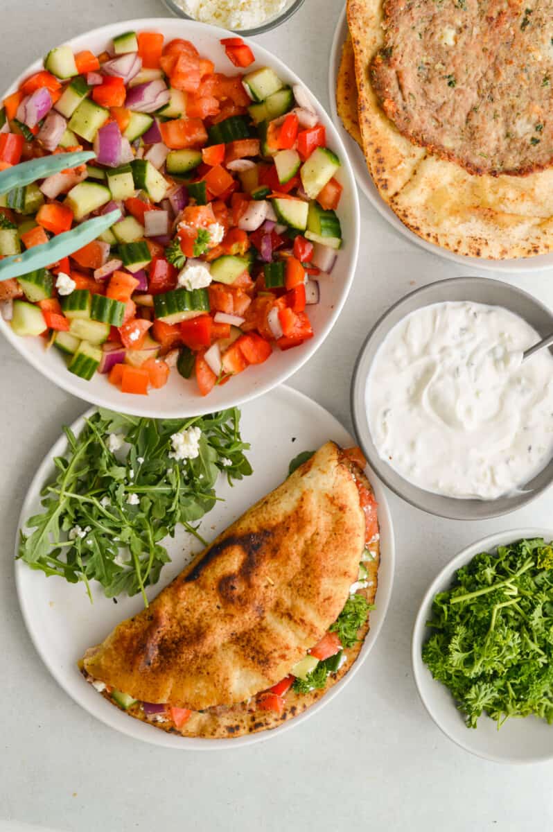 Birds eye of chopped Mediterranean salad, tzatziki and Greek smashed turkey burger pitas.