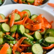 White bowl of cucumber and carrot salad.