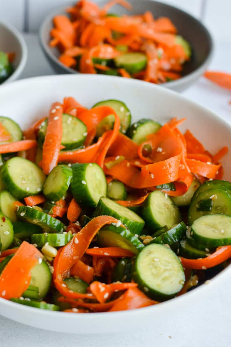 White bowl of cucumber and carrot salad.