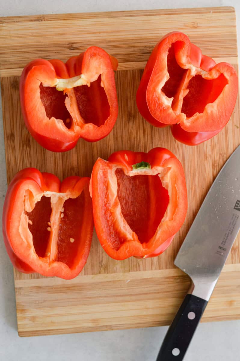 Slicing red bell peppers in half.