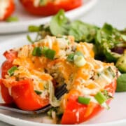 Cutting open a tuna stuffed red bell pepper with a fork.