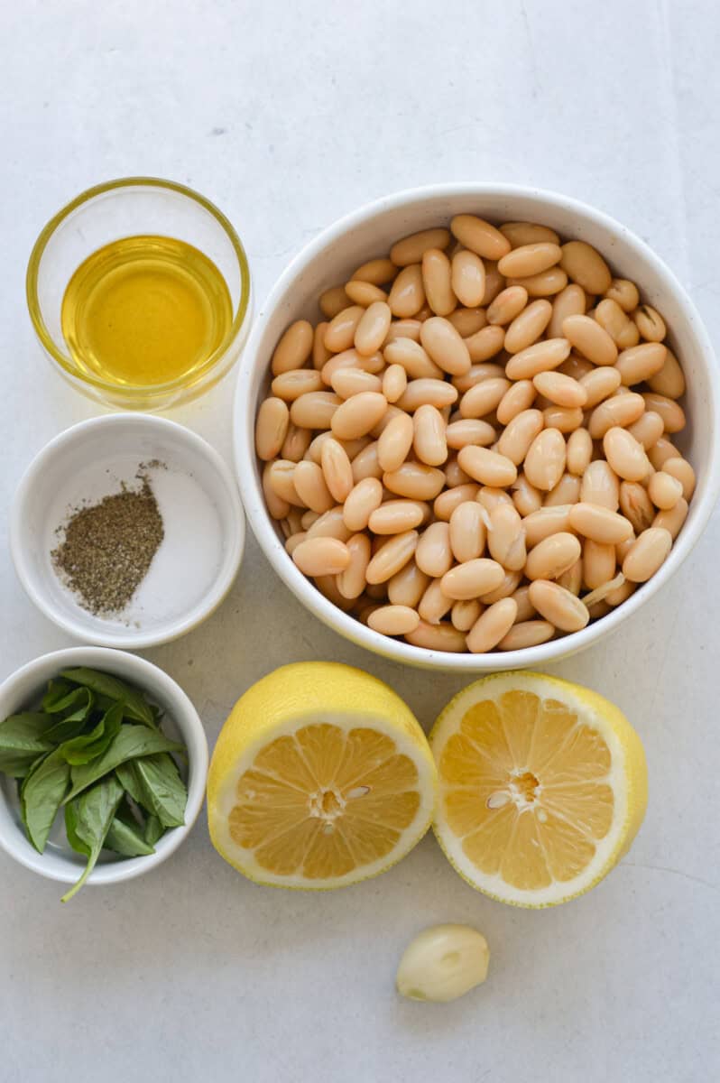 Ingredients including white beans, lemon, fresh basil, salt and pepper, and olive oil.