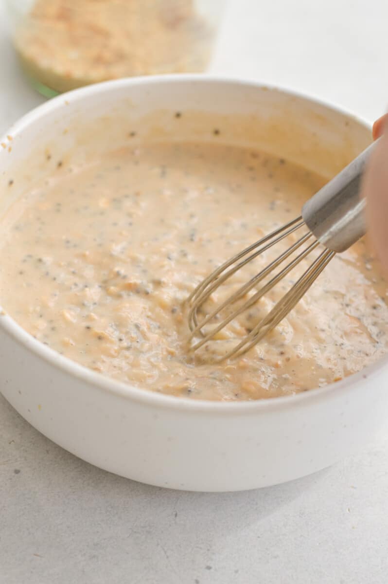 Mixing banana oats in a bowl with a whisk.