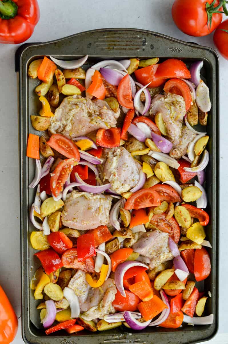 Sheet pan of chicken thighs, bell peppers and potatoes.