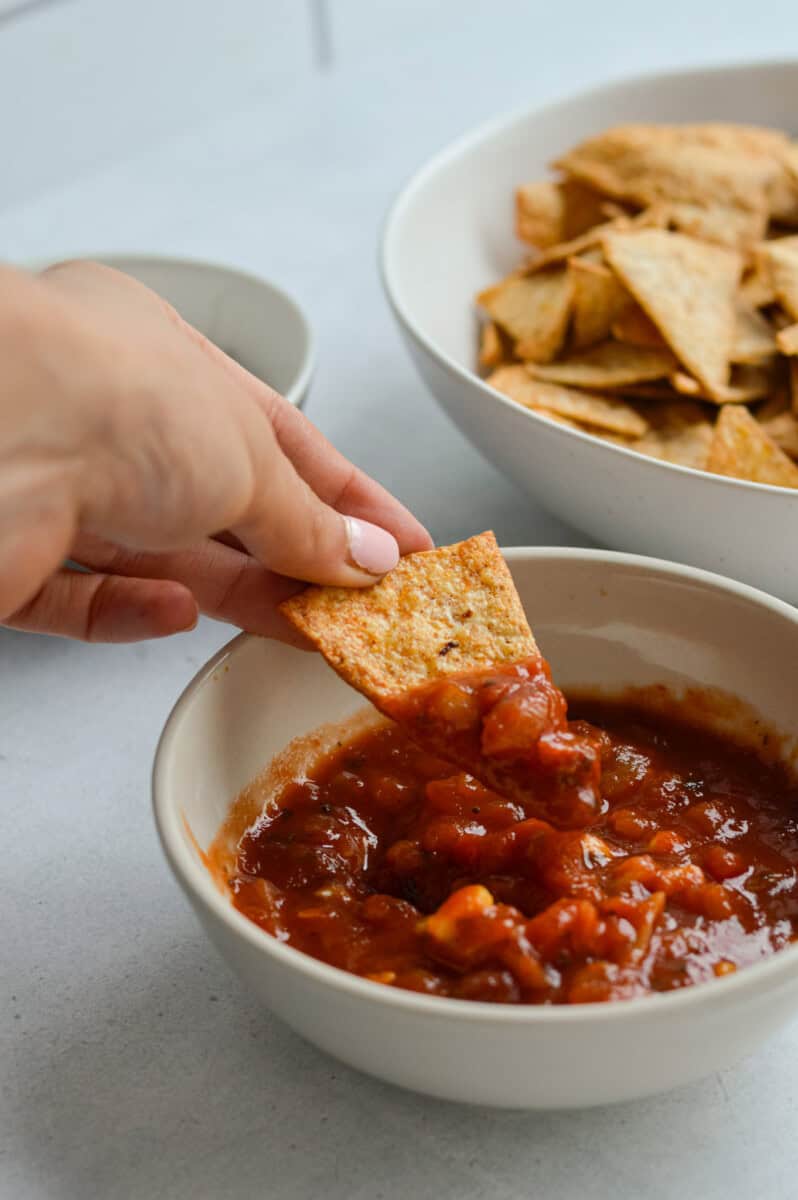 Dipping a tortilla chip in salsa.