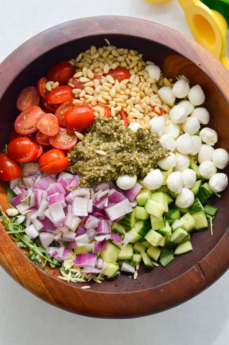 Orzo pesto salad with cherry tomatoes, bocconcini, cucumber, red onion, pine nuts and arugula.