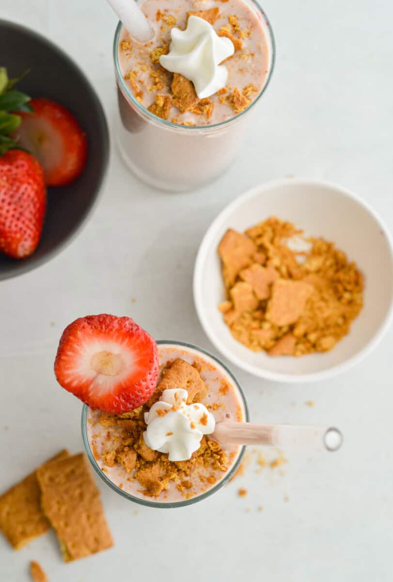 Birds eye of two cheesecake cottage cheese smoothies topped with graham cracker crumbs.