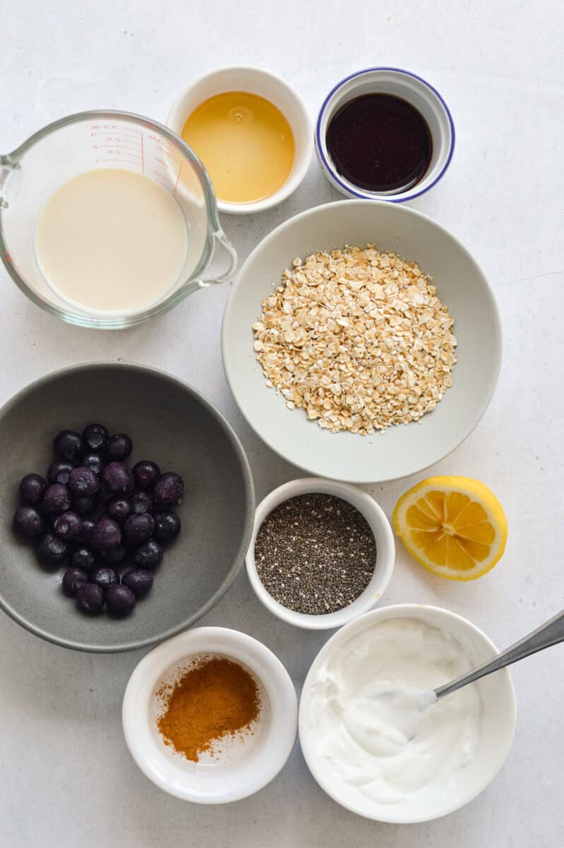 Ingredients including blueberries, oats, Greek yogurt, lemon, cinnamon, honey, chia seeds, protein powder and milk.