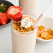 Cheesecake cottage cheese smoothie topped with graham crumbs, whipped cream and a strawberry.