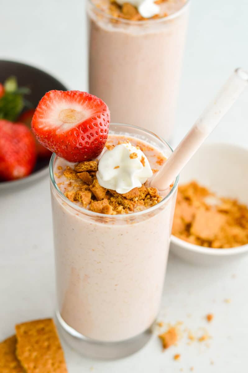 Cheesecake cottage cheese smoothie topped with graham crumbs, whipped cream and a strawberry.