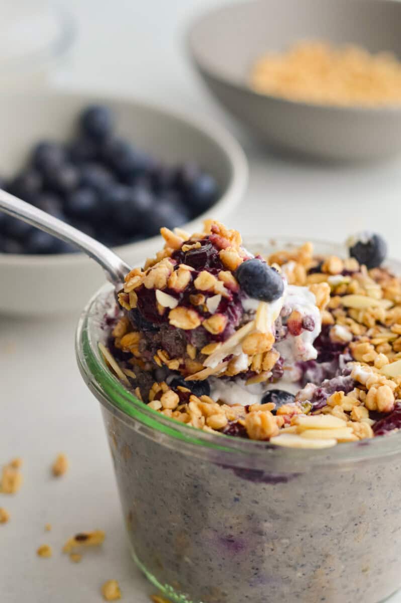 Close up of blueberry overnight oats topped with almonds, blueberrys, granola and Greek yogurt.
