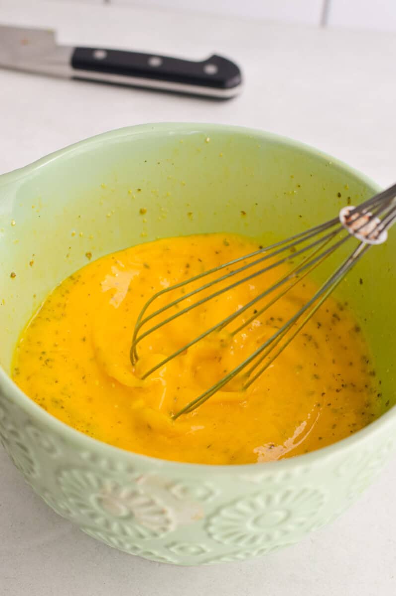 Whisking eggs, milk, cottage cheese, salt, pepper, Italian seasoning and garlic powder in a bowl.