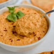 scooping roasted red pepper lentil hummus