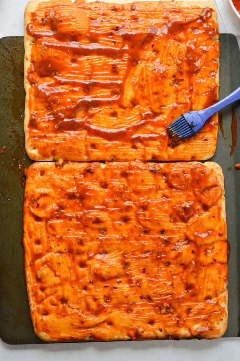 Adding bbq sauce to a flatbread.