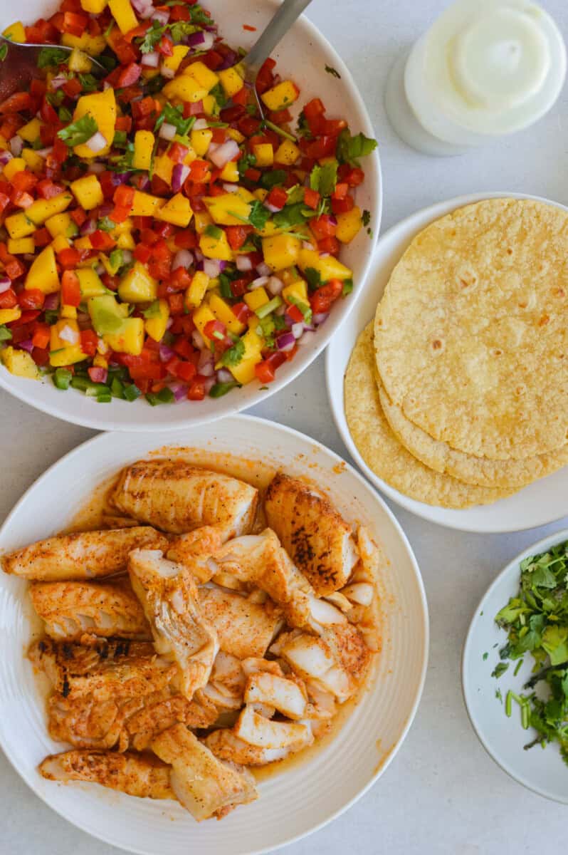 Bowl of corn salsa, corn tortillas and fish.