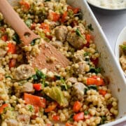Close up of tray with baked feta and sausage couscous.
