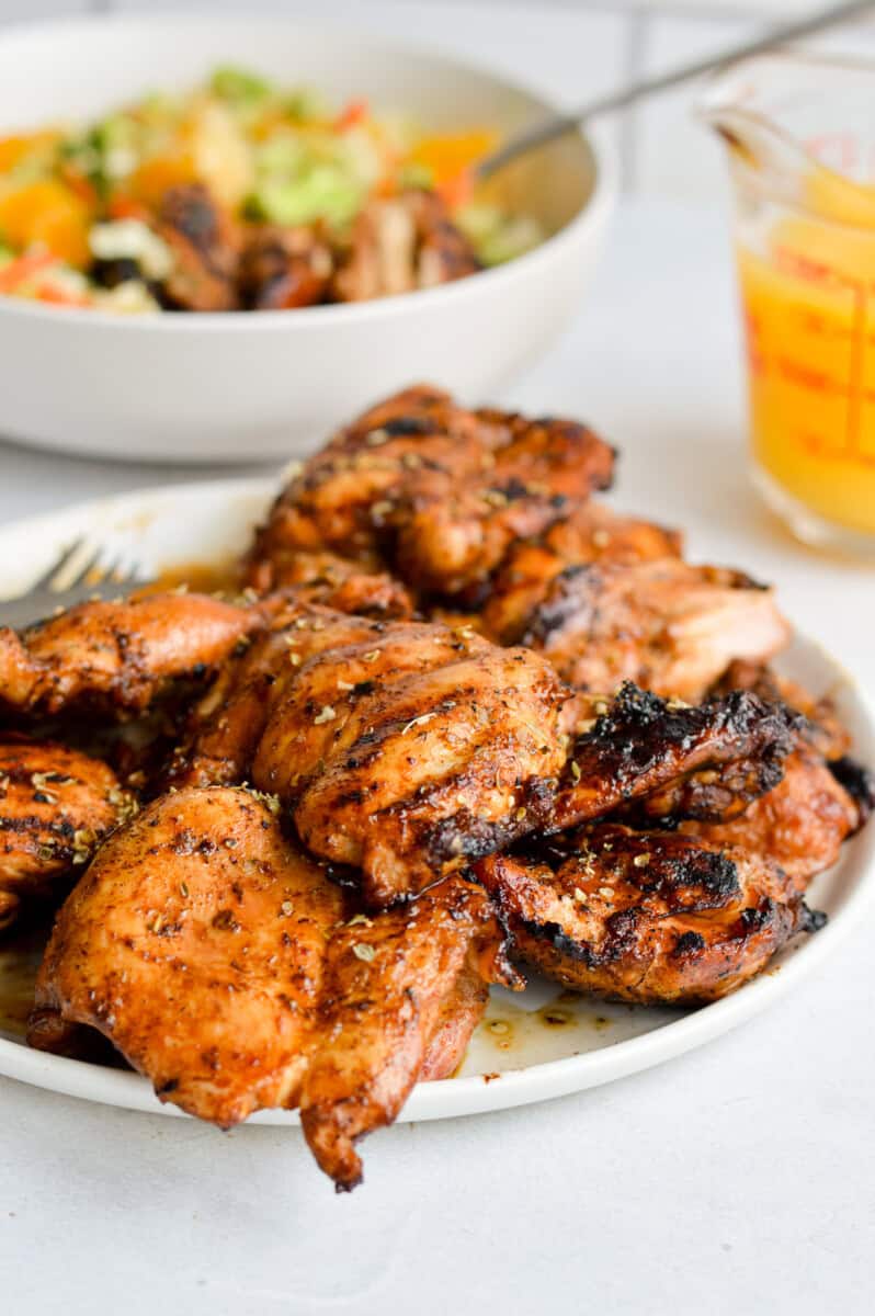Close up of grilled boneless chicken thighs on a plate.