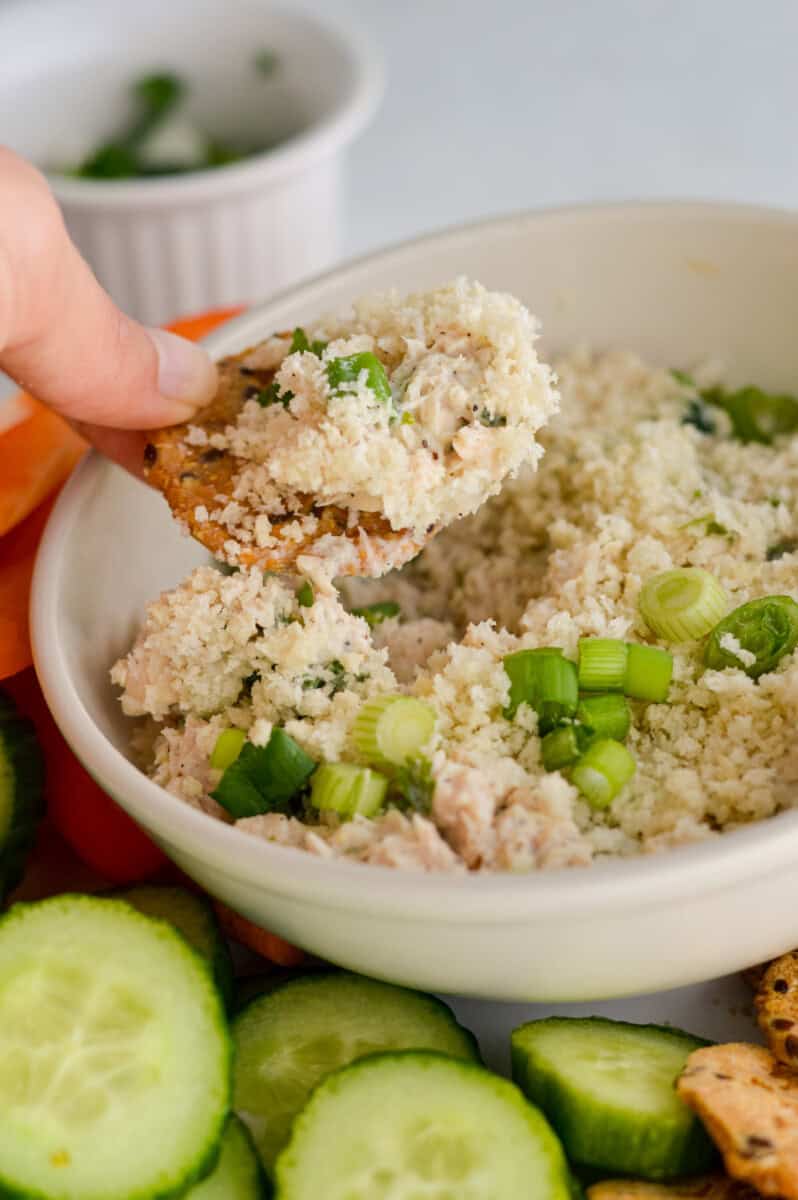 Dipping a cracker in tuna dip.