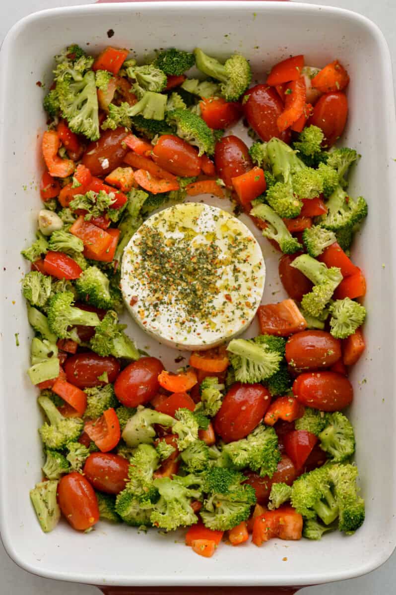 Adding a block of feta to vegetables.