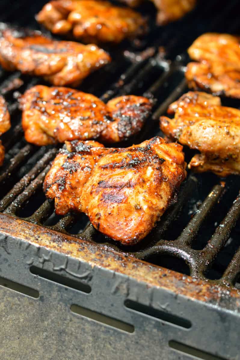 Grilling boneless chicken thighs on a barbecue.