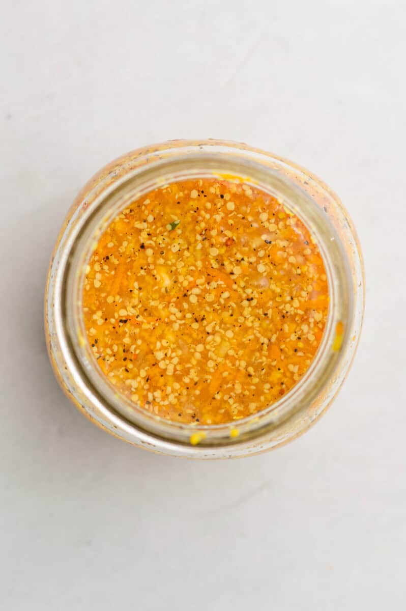 Birds eye of a jar with orange salad dressing.