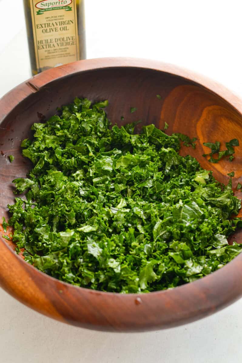 Massaging kale in a bowl.