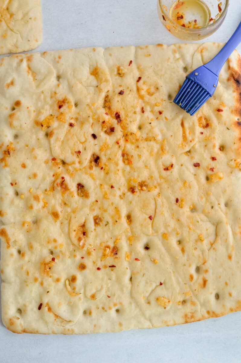 Brushing flatbread with olive oil.