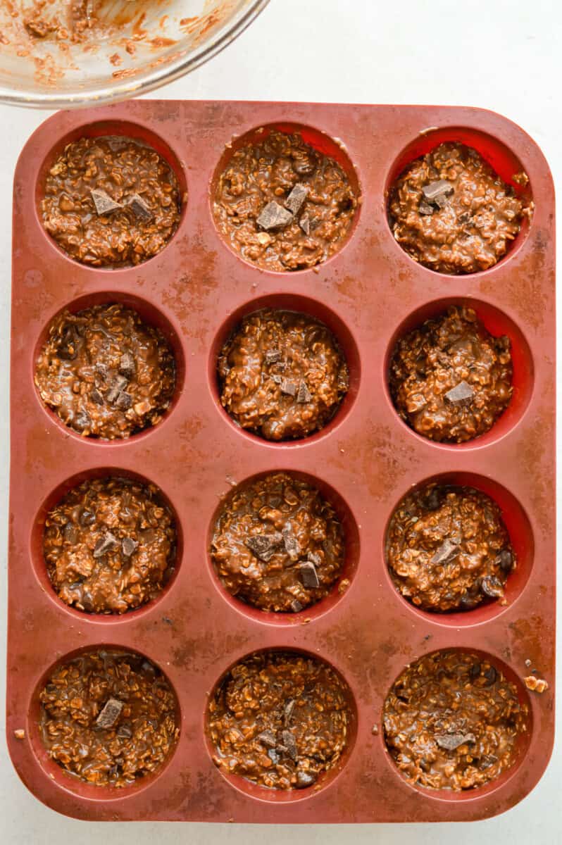 Divide your batter evenly among the cavities of your muffin tin (recipe should make about 12 baked oatmeal cups). *I typically pour about ¼ cup of batter into each cavity.