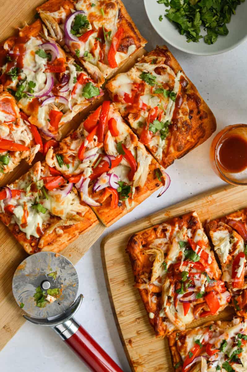 Slicing a BBQ chicken flatbread into 6 equal slices.