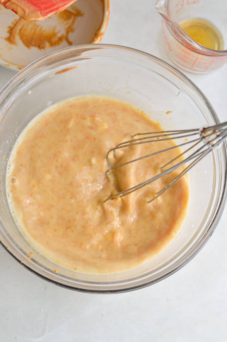 In a large mixing bowl combine mashed banana, milk, maple syrup, eggs and peanut butter and whisk until smooth. 

