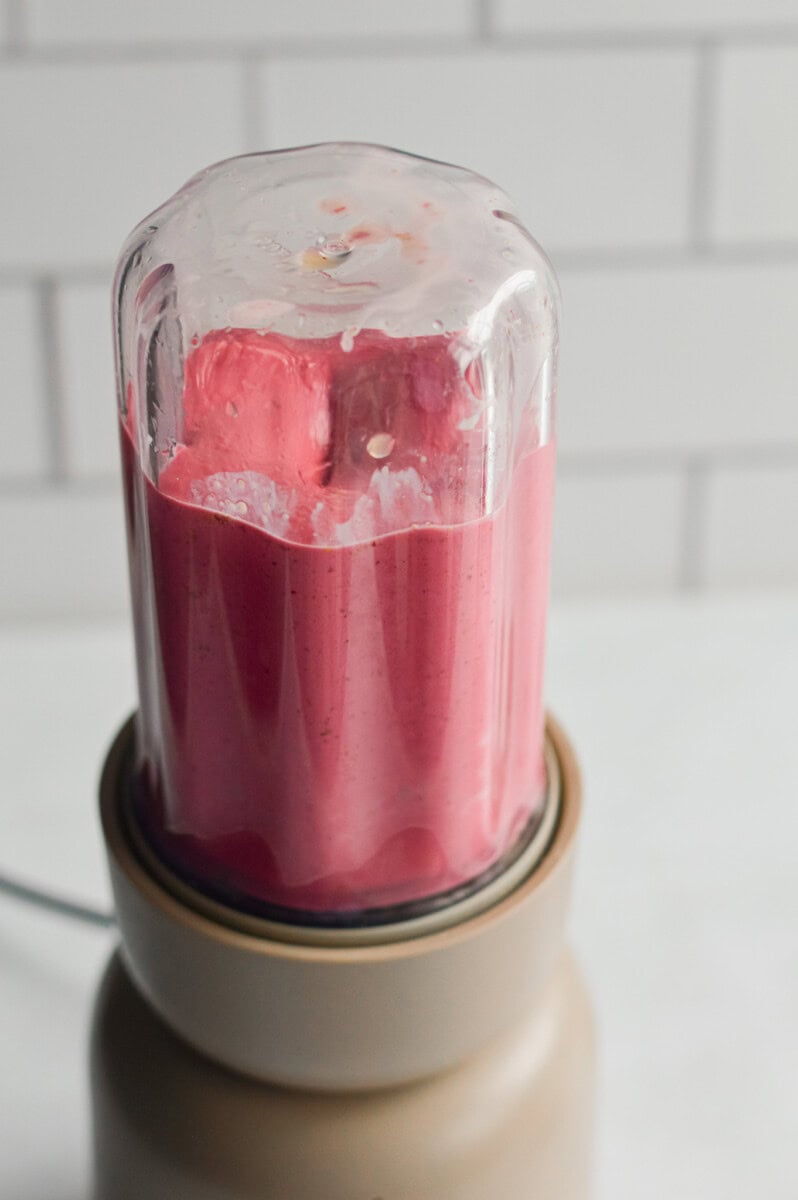 Blending pink fruit smoothie recipe.