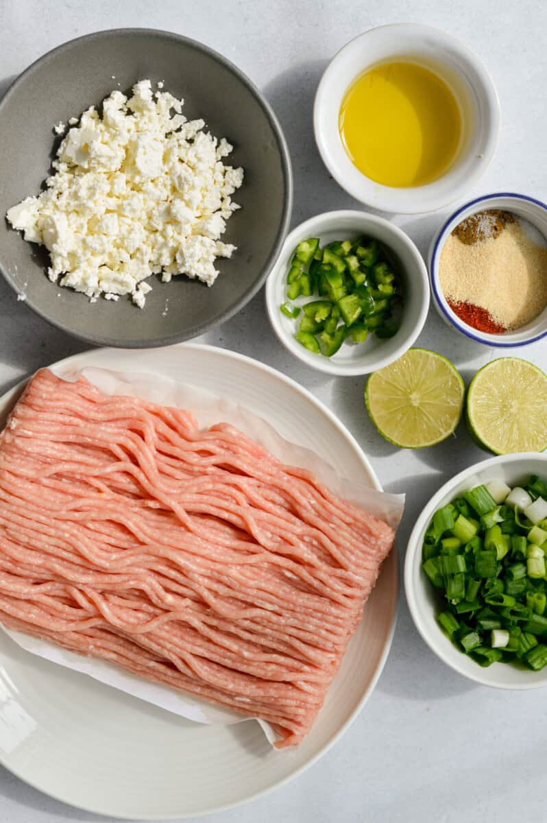 Ingredients including ground chicken, feta, green onion, lime juice, jalapenos, olive oil and seasoning.