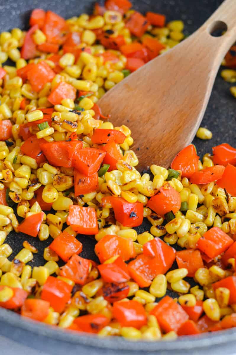 Cooking Mexican street corn on a pan.